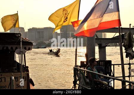 Ein Touristenboot, das sich einer Wasserbusstation nähert, die mit einer thailändischen Nationalflagge am Ufer des Chao Phraya Flusses in Bangkok City (Krung Thep Maha Nakhon), Thailand, dekoriert ist. Das thailändische Ministerium für Tourismus und Sport berichtete über bedeutende Erfolge im Tourismus in den ersten sechs Monaten des Jahres 2024, dank der unterstützenden Politik der Regierung, wie die Öffentlichkeitsabteilung des Landes am 7. Juli 2024 mitteilte. Thailand begrüßte von Januar bis Juni 2024 über 17,5 Millionen internationale Touristen und erzielte einen Umsatz von mehr als 825 Milliarden Baht (mehr als 22 Milliarden USD). Stockfoto