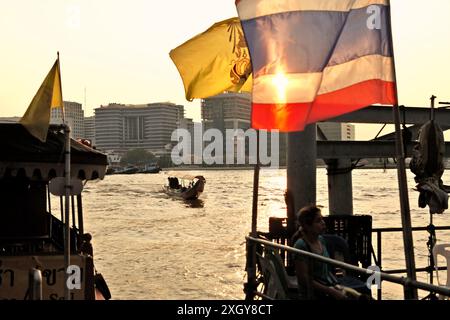 Ein Touristenboot, das sich einer Wasserbusstation nähert, die mit einer thailändischen Nationalflagge am Ufer des Chao Phraya Flusses in Bangkok City (Krung Thep Maha Nakhon), Thailand, dekoriert ist. Das thailändische Ministerium für Tourismus und Sport berichtete über bedeutende Erfolge im Tourismus in den ersten sechs Monaten des Jahres 2024, dank der unterstützenden Politik der Regierung, wie die Öffentlichkeitsabteilung des Landes am 7. Juli 2024 mitteilte. Thailand begrüßte von Januar bis Juni 2024 über 17,5 Millionen internationale Touristen und erzielte einen Umsatz von mehr als 825 Milliarden Baht (mehr als 22 Milliarden USD). Stockfoto