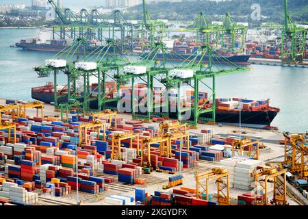 Blick auf ein Containerterminal am Hafen von Singapur. Frachtschiffe haben im Hafen angedockt. Schiffs-to-Shore (STS)-Portalkrane Be- und Entladen von Schiffen A Stockfoto