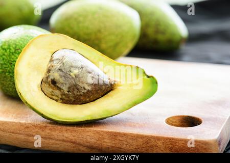 Nahaufnahme der frischen Reifen Avocado auf hölzernem Schneidebrett. Gesunde Öko-Lebensmittel. Erzeugnis des ökologischen Landbaus. Stockfoto