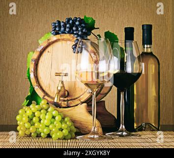 Set aus Rot- und Weißwein. Weinflaschen, Gläser Wein, Holzfässer und reife Trauben auf dem Tisch. Weinerzeugnis. Stockfoto