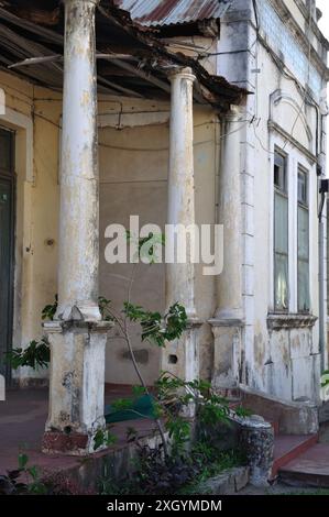 Altes Kolonialhaus in schlechtem Zustand, Stadt Inhambane, Provinz Inhambane, Mosambik; Portikus; Säulen; schlecht gepflegt, muss neu lackiert und repariert werden Stockfoto