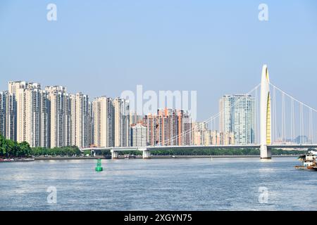 Malerischer Blick auf die Liede Bridge über den Perlfluss in Guangzhou, China. Wohnhochhäuser sind auf blauem Himmel zu sehen. Stockfoto