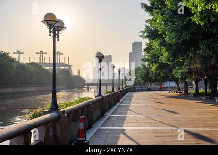 Wunderbarer Blick auf die Straßenlaternen am Ufer des Perlflusses vor untergehender Sonne in der Innenstadt von Guangzhou, China. Stadtbild bei Sonnenuntergang. Stockfoto