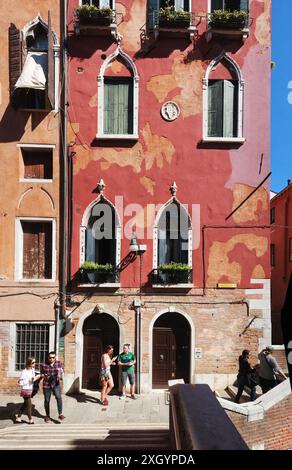 Venedig, Italien, Ein hoher palazzo in der Nähe des Campo Santa Maria Formosa mit venezianischen gotischen Fenstern, rotem Stuck, Fensterläden und Blumenkästen auf der oberen Ebene Stockfoto