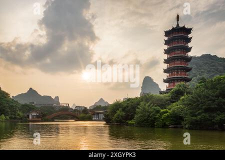 Herrlicher Abendblick auf den Mulong Lake (hölzerner Drachensee) zwischen grünen Wäldern und malerischen Karstbergen in Guilin, China. Stockfoto