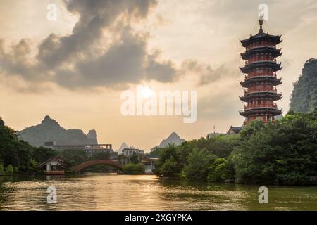 Herrlicher Abendblick auf den Mulong Lake (hölzerner Drachensee) zwischen grünen Wäldern und malerischen Karstbergen in Guilin, China. Stockfoto