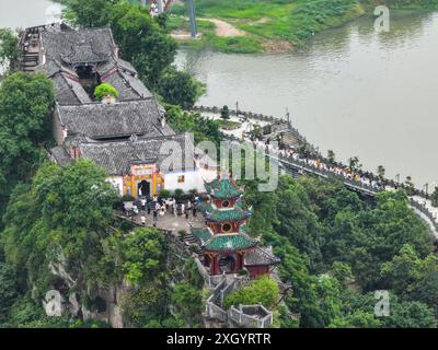 Chongqing. Juli 2024. Ein Drohnenfoto vom 10. Juli 2024 zeigt Shibaozhai, einen malerischen Ort im Zhongxian County im Südwesten Chinas in Chongqing. Shibaozhai sieht aus wie ein herzförmiger Bonsai, der mitten im Abschnitt der drei Schluchten von Yangtse Rier sitzt. Hier befindet sich eine 12-stöckige, 56 Meter hohe Holzpagode, die auf 20 Säulen steht und sich gegen die Klippe neigt. Dieses Gebäude stammt aus der Ming-Dynastie (1368–1644) und ist eine der wichtigsten Touristenattraktionen von Shibaozhai. Quelle: Huang Wei/Xinhua/Alamy Live News Stockfoto