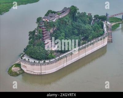 Chongqing. Juli 2024. Ein Drohnenfoto vom 10. Juli 2024 zeigt Shibaozhai, einen malerischen Ort im Zhongxian County im Südwesten Chinas in Chongqing. Shibaozhai sieht aus wie ein herzförmiger Bonsai, der mitten im Abschnitt der drei Schluchten von Yangtse Rier sitzt. Hier befindet sich eine 12-stöckige, 56 Meter hohe Holzpagode, die auf 20 Säulen steht und sich gegen die Klippe neigt. Dieses Gebäude stammt aus der Ming-Dynastie (1368–1644) und ist eine der wichtigsten Touristenattraktionen von Shibaozhai. Quelle: Huang Wei/Xinhua/Alamy Live News Stockfoto