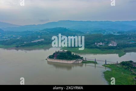 Chongqing. Juli 2024. Ein Drohnenfoto vom 10. Juli 2024 zeigt Shibaozhai, einen malerischen Ort im Zhongxian County im Südwesten Chinas in Chongqing. Shibaozhai sieht aus wie ein herzförmiger Bonsai, der mitten im Abschnitt der drei Schluchten von Yangtse Rier sitzt. Hier befindet sich eine 12-stöckige, 56 Meter hohe Holzpagode, die auf 20 Säulen steht und sich gegen die Klippe neigt. Dieses Gebäude stammt aus der Ming-Dynastie (1368–1644) und ist eine der wichtigsten Touristenattraktionen von Shibaozhai. Quelle: Liu Chan/Xinhua/Alamy Live News Stockfoto