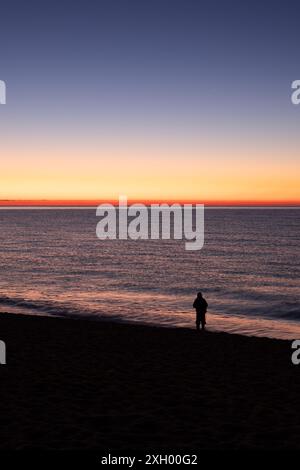 Die Ruhe des Canet Beach bei Sonnenaufgang wird festgehalten, während sich das erste Licht des Tages vom ruhigen Wasser reflektiert. Die ruhige Landschaft wird durch die verstärkt Stockfoto