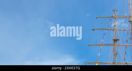 Internationale Seesignale Flaggen auf einem Fahnenmast und Masten auf einem Segelschiff mit blauem Himmel im Hintergrund. Banner Stockfoto