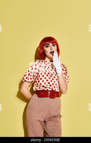 Eine lebendige rothaarige Frau mit Polka Dots und auffälligem Make-up vor gelbem Hintergrund, die einer Figur aus Comics ähnelt. Stockfoto