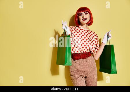 Eine rothaarige Frau mit Pop-Art-Make-up, die Einkaufstaschen auf gelbem Hintergrund hält. Stockfoto