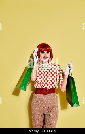 Hübsche rothaarige Frau mit kreativem Pop Art Make-up und Punktbluse auf gelbem Hintergrund. Stockfoto