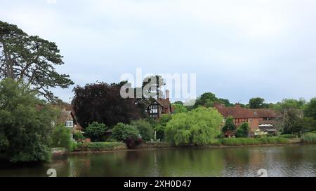 Beaulieu, Brockenhurst, England. 30. Juni 2024. National Motor Museum, Beaulieu. Eine Weitwinkellandschaft des Beaulieu River gesäumt von Bäumen und Häusern. Stockfoto