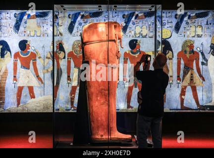 Köln, Deutschland. Juli 2024. Ein Mann fotografiert den Sarkophag von Ramses II. Im Odysseum. Die Ausstellung „Ramses & das Gold der Pharaonen“ ist ab 13. Juni 2024 in Köln zu sehen. Das Herzstück ist der echte Sarkophag von Ramses II. Alle Objekte stammen aus Museen und historischen Stätten in Ägypten. Quelle: Oliver Berg/dpa/Alamy Live News Stockfoto