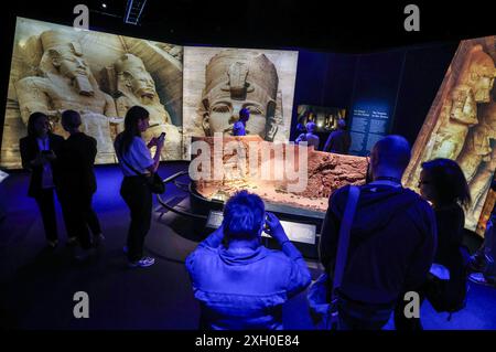 Köln, Deutschland. Juli 2024. Besucher sehen ein Modell des Tempels von Abu Simbel im Odysseum. Die Ausstellung „Ramses & das Gold der Pharaonen“ ist ab 13. Juni 2024 in Köln zu sehen. Das Herzstück ist der echte Sarkophag von Ramses II. Alle Objekte stammen aus Museen und historischen Stätten in Ägypten. Quelle: Oliver Berg/dpa/Alamy Live News Stockfoto