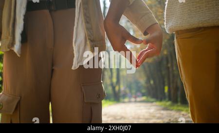 Glückliche Familie romantisches zärtliches multiethnisches Paar indischer arabischer Mann Freund männlicher hispanischer Freundin Frau weibliches Lächeln zeigt Herzform Geste Stockfoto