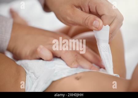 Mutter, Hände und Wickelwindel zu Hause, schützen Ihr Baby und lieben es für Kleinkinder oder Routinekleidung. Mama, Kind und Windel für Kind im Schlafzimmer oder beim Putzen Stockfoto