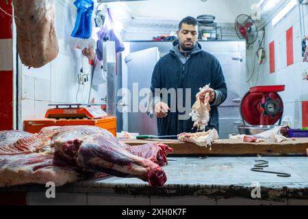 Ein marokkanischer Metzger bereitet mehrere Stücke Halal-Fleisch für den Verkauf auf einem Markt in der Medina von Fès in Marokko, Nordafrika, zu Stockfoto