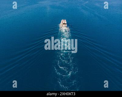 Oben über der Luftdrohne sehen Sie Luxus-Motoryacht Segeln in türkisblauem Meerwasser mediterrane Landschaft Hintergrund an sonnigen Sommertagen. Motorboot Stockfoto