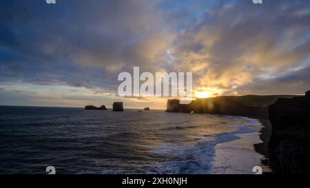 Sonnenuntergang über den dramatischen Felsformationen und der Küste von Dyrhólaey in Island. Stockfoto