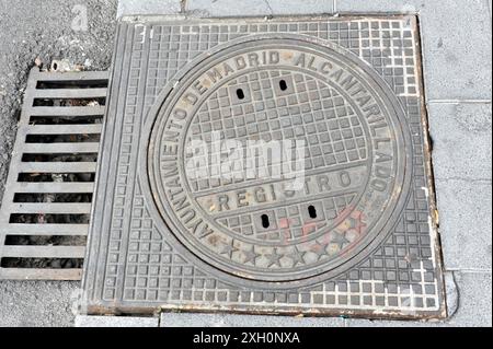 Madrid, Spanien, Europa, runder Schachtdeckel aus Metall mit Schriftzug auf einem Bürgersteig in Madrid Stockfoto