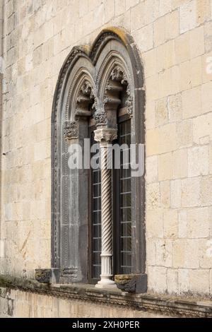 Gotisches Bogenfenster mit kunstvoller Spiralsäule: Mittelalterliche Kirchenarchitektur in Steinmauerwerk Stockfoto