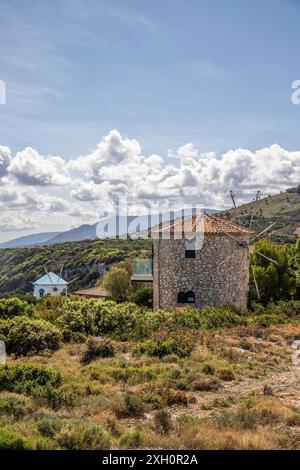 Tolle typisch griechische Windmühle am Abend. Im mediterranen Architekturstil Griechenlands. Es steht auf einer Klippe im Mittelmeer. Potamitis Stockfoto