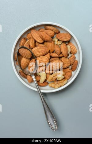 Mandeln und Walnüsse in Schale mit Löffel, verschiedene Nüsse Stockfoto