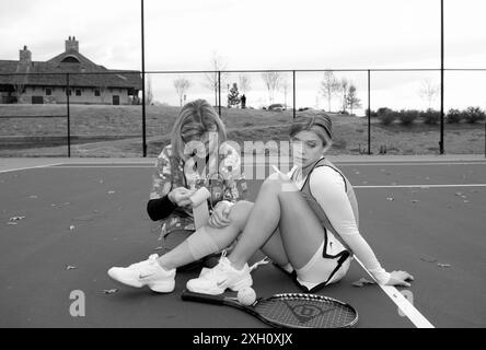 Stockfoto zeigt weibliche Gesundheitsberaterin mit Stethescope, die Bandage um das Bein eines kaukasischen Teenagermädchen-Tennisspielers von 15 bis 17 Jahren wickelt. Sh Stockfoto