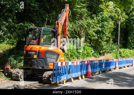 Shiplake, Oxfordshire, Großbritannien. Juli 2024. Wasserbauunternehmen von Thames bauen neue Rohre an einer Hauptstraße in Shiplake, Oxfordshire. Die Wasseraufsichtsbehörde OFWAT hat heute angekündigt, dass das Wasser der Themse aufgrund „erheblicher Probleme“ in Sondermaßnahmen einbezogen werden soll. Kunden von Thames Water sehen sich in den nächsten fünf Jahren mit einer Erhöhung ihrer Rechnungen um 99 £ oder 23 % konfrontiert. Die Wasserversorgung der Themse wurde vielfach wegen ihrer geringen Abwassereinleitungen, mangelnder Infrastrukturverbesserungen und Zahlungen an ausländische Aktionäre kritisiert. Bis Mai 2025 wird das Geld für das Wasser der Themse ausgehen. Die neue Labour-Regierung Stockfoto