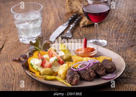 Cevapcici auf einer Platte mit Spänen Stockfoto