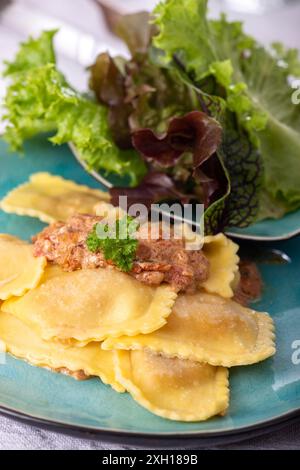 Ravioli mit Sahnesauce und Salat Stockfoto