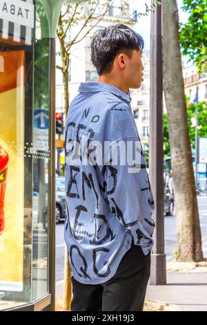 Junger orientalischer Mann mit handbemaltem, gestreiftem Baumwollhemd - Paris 75004, Frankreich. Stockfoto