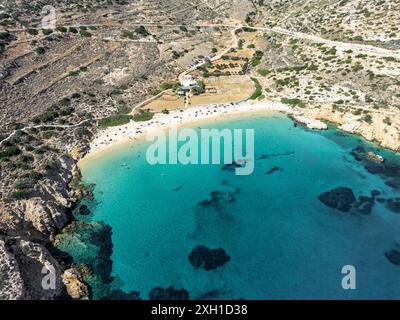 Kedros Strand auf Donousa: Abgeschiedener Halbmond aus Sand zwischen Klippen. Türkisfarbenes Wasser schimmert im Sonnenlicht und lädt zum Entspannen ein Stockfoto