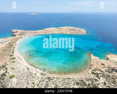 Ein ruhiger Blick aus der Vogelperspektive auf den Strand Pori in Koufonisia, Griechenland, mit dem türkisfarbenen Wasser und einer Handvoll Boote, die in der Bucht vor Anker liegen. Stockfoto