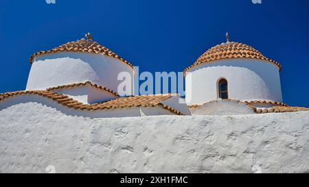 Zwei weiß bemalte Kirchtürme mit roten Ziegeldächern und kleinen Fenstern, hellblauer Himmel, Chora, Altstadt, Patmos, Dodekanesisch, Griechische Inseln, Griechenland Stockfoto