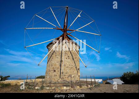 Steinwindmühle mit einem klaren blauen Himmel im Hintergrund und einer natürlichen Umgebung, Windmühlen, auf einem Kamm, oberhalb von Chora, der Hauptstadt von Patmos, Patmos Stockfoto