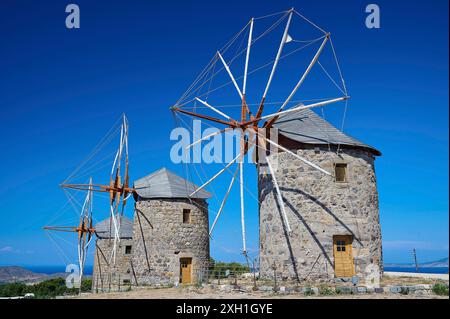 Drei alte Windmühlen vor einem klaren blauen Himmel und einer natürlichen Landschaft, Windmühlen, auf einem Kamm, oberhalb von Chora, Hauptstadt Patmos, Patmos, Altstadt Stockfoto