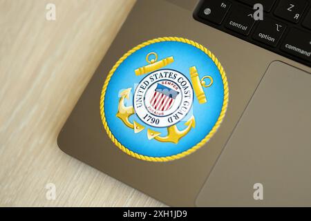 KIEW, UKRAINE - 26. JUNI 2024 Wappenaufkleber der US-Küstenwache auf silbernem Laptop in Nahaufnahme Stockfoto