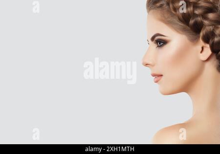 Porträt einer schönen glücklichen Frau mit langen Wimpern, wunderschönem Make-up, dicken Augenbrauen und sauberer Haut und geflochtenem Haar. Wimpernverlängerungen. M Stockfoto