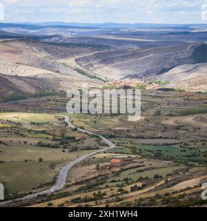 Atemberaubender Blick aus der Luft, der die ländliche Landschaft und die gewundenen Straßen, die nach Villarroya de los Pinares in Teruel, Spanien, führen, umgeben von malerischen Hügeln Stockfoto