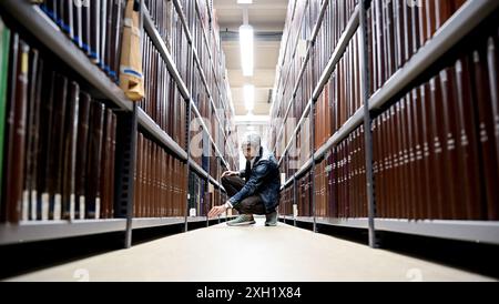 Berlin, Deutschland. Juli 2024. Jonas Fansa, Betriebsdirektor der Zentral- und Landesbibliothek Berlin, prüft nach Wasserschäden in einem Gebäude der Zentral- und Landesbibliothek die Bücher in den Regalen. Quelle: Britta Pedersen/dpa/Alamy Live News Stockfoto