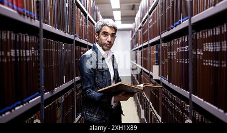 Berlin, Deutschland. Juli 2024. Jonas Fansa, Betriebsdirektor der Zentral- und Landesbibliothek Berlin, prüft nach Wasserschäden in einem Gebäude der Zentral- und Landesbibliothek die Bücher in den Regalen. Quelle: Britta Pedersen/dpa/Alamy Live News Stockfoto