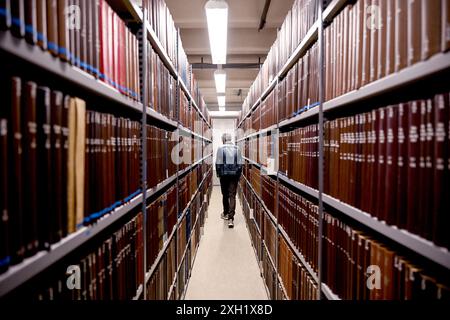 Berlin, Deutschland. Juli 2024. Jonas Fansa, Betriebsdirektor der Zentral- und Landesbibliothek Berlin, prüft nach Wasserschäden in einem Gebäude der Zentral- und Landesbibliothek die Bücher in den Regalen. Quelle: Britta Pedersen/dpa/Alamy Live News Stockfoto