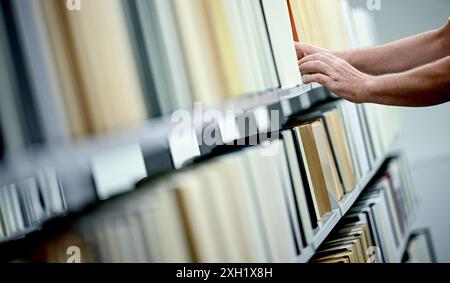 Berlin, Deutschland. Juli 2024. Roland Pape, Medien- und Informationsspezialist, trocknet und prüft Bücher nach Wasserschäden in der Zentral- und Landesbibliothek Berlin auf Feuchtigkeit. Quelle: Britta Pedersen/dpa/Alamy Live News Stockfoto