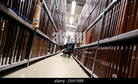 Berlin, Deutschland. Juli 2024. Jonas Fansa, Betriebsdirektor der Zentral- und Landesbibliothek Berlin, prüft nach Wasserschäden in einem Gebäude der Zentral- und Landesbibliothek die Bücher in den Regalen. Quelle: Britta Pedersen/dpa/Alamy Live News Stockfoto