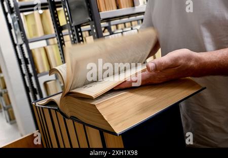 Berlin, Deutschland. Juli 2024. Roland Pape, Medien- und Informationsspezialist, trocknet und prüft Bücher nach Wasserschäden in der Zentral- und Landesbibliothek Berlin auf Feuchtigkeit. Quelle: Britta Pedersen/dpa/Alamy Live News Stockfoto